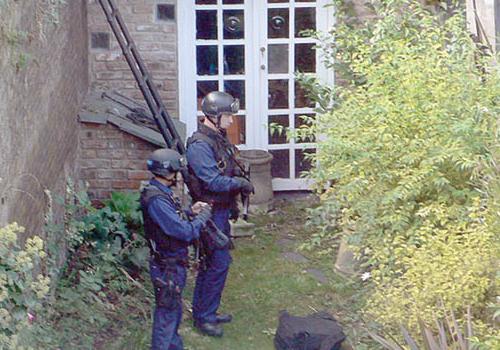 Armed police officers in the back garden of an Upper Holloway house following th