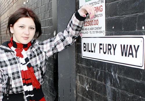 Andrea Masala poses next to the Billy Fury Way sign