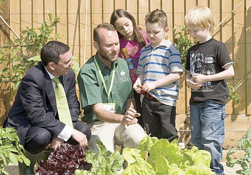 Royal Parks chief executive Mark Camley and Nick Lane gardening with children