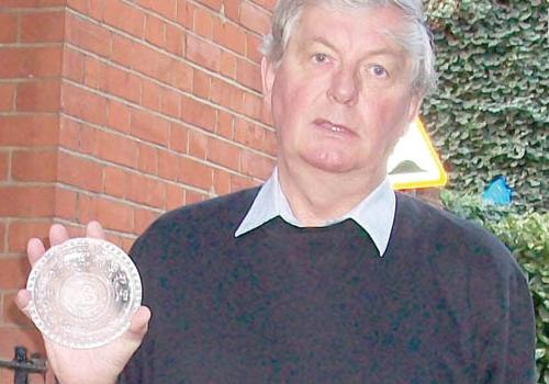 Len Rutter holds the dish tribute to George Peabody which dates back to 1869. 