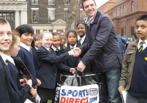 Lee Sharpe handing over footballs to pupil Smilla Kristenson