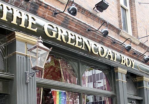 The Greencoat Boy with a rainbow flag hanging in the window