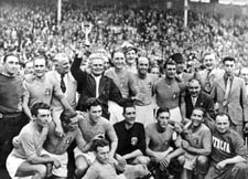 Vittorio Pozzo with the World Cup and his winning team after the victory in the final against Hungary in Paris in 1938. 